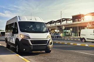 Vit minibuss vid busstation